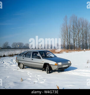 Ein Citroen BX e Ende der 1980er Jahre in einer Winterlandschaft in der Nähe der bayrischen Stadt München. Ein Citroen BX ist in den späten 1980er Jahren in einer Winterlandschaft in der Nähe der bayerischen Landeshauptstadt München. Stockfoto