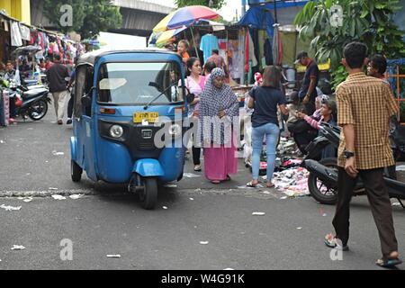 Jakarta, Indonesien - Juni 2019: Blick auf eine Straße mit blauen Bajaj in der Nähe von Asemka Markt, Jakarta. Stockfoto