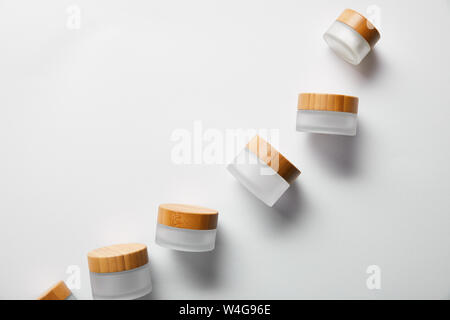 Blick von oben auf die leeren Gläser mit Holz- Kappen auf Weiß Stockfoto