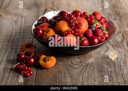 Platte mit gemischten köstliche reife Beeren auf hölzernen Tisch Stockfoto