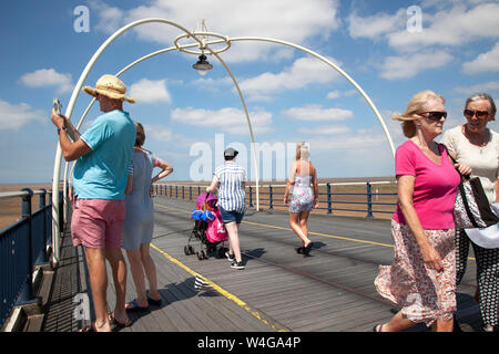 Southport, Merseyside. UK Wetter. 23. Juli 2017. 28°C an der Küste wie Kinderwagen in Shorts, sun Hüte genießen Sie eine Brise auf der Resorts Promenade. Credit: MediaWorldImages/AlamyLiveNews Stockfoto