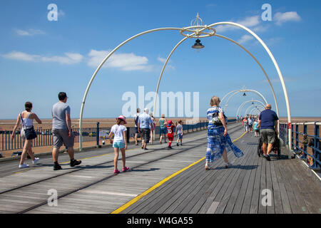 Southport, Merseyside. UK Wetter. 23. Juli 2017. 28°C an der Küste wie Kinderwagen in Shorts, sun Hüte genießen Sie eine Brise auf der Resorts Promenade. Credit: MediaWorldImages/AlamyLiveNews Stockfoto