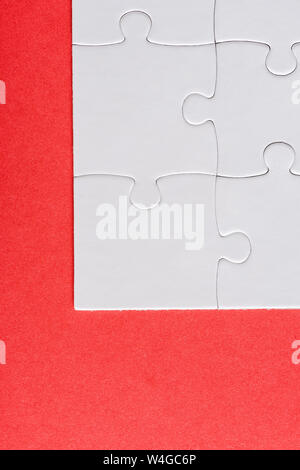 Blick von oben auf die weiße verbunden Puzzle Stück auf Rot isoliert Stockfoto