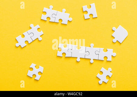 Blick von oben auf die angeschlossenen Puzzle Stücke isoliert auf Gelb Stockfoto