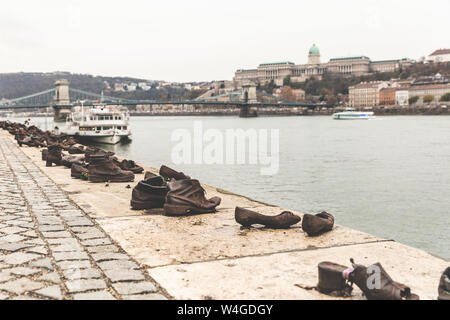 Waterside schuh Skulpturen aus dem Zweiten Weltkrieg zu gedenken, die Kettenbrücke und die Budaer Burg auf Hintergrund, Budapest, Ungarn Stockfoto