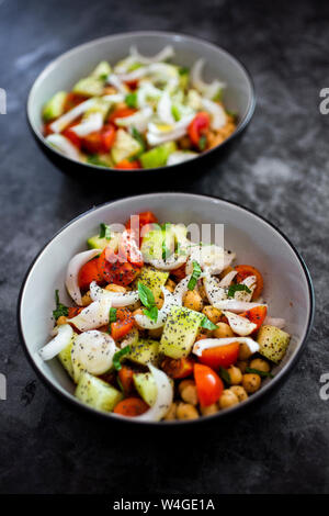 Salat mit Gurken, Kichererbsen, Zwiebeln, Tomaten, Basilikum, Chia Samen Stockfoto