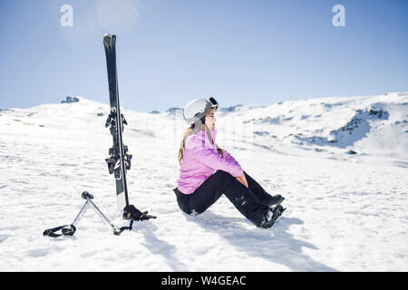 Frau eine Pause nach dem Skifahren auf dem verschneiten Boden in Sierra Nevada, Andalusien, Spanien Stockfoto