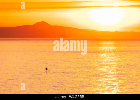 Mann auf Stand up Paddle Board bei Sonnenuntergang, North Berwick, East Lothian, Schottland Stockfoto