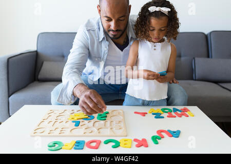 Vater und Tochter spielen mit Alphabet lernen Spiel zu Hause Stockfoto