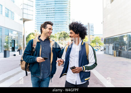 Zwei glückliche casual Geschäftsleute mit Handys Treffen in der Stadt, Barcelona, Spanien Stockfoto