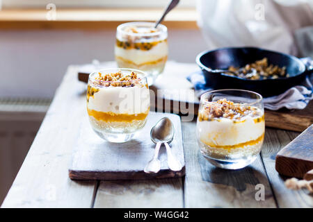 Ungebackene Käsekuchen in einem Glas mit Passionsfrucht und Mutter spröde Stockfoto