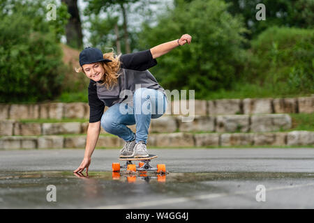 Junge Frau balancieren auf skateboard Stockfoto