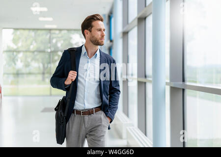 Junge Unternehmer zu Fuß in einer Passage Stockfoto