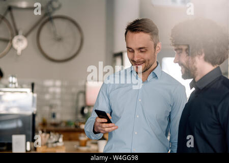 Business Partner in einem Coffee Shop in einer Konferenz können Sie ihr Smartphone Stockfoto