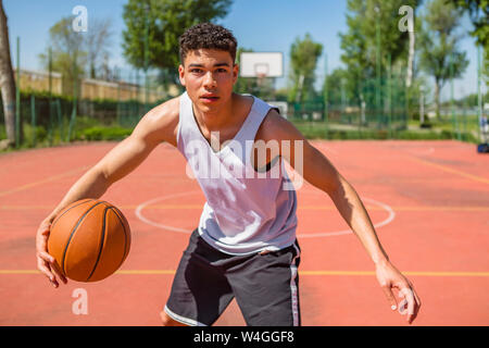 Junger Mann, Basketball spielen Stockfoto