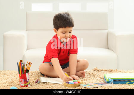 Junge Färbung ein Buch in einem Wohnzimmer Stockfoto