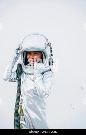 Portrait von Lachen kleines Mädchen tragen Anzug und Hut vor weißem Hintergrund Stockfoto