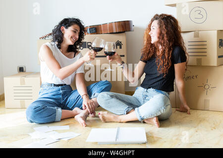 Zwei Freunde, die sich in die neue Heimat klirren Rotwein Gläser Stockfoto