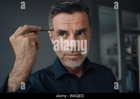 Portrait von Reifen Geschäftsmann Holding eine rostige Schraube Stockfoto