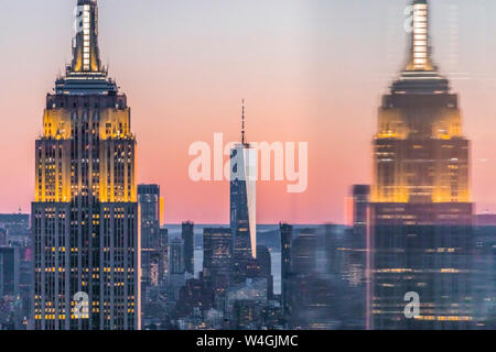 Skyline bei Sonnenuntergang mit Empire State Building im Vordergrund und das One World Trade Center im Hintergrund, Manhattan, New York City, USA Stockfoto