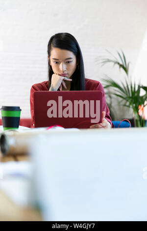 Frau mit Laptop im Büro Stockfoto