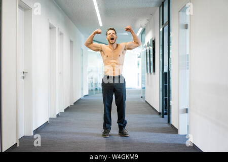 Schreien barechested Geschäftsmann flexing Muskeln im Büro Stockfoto