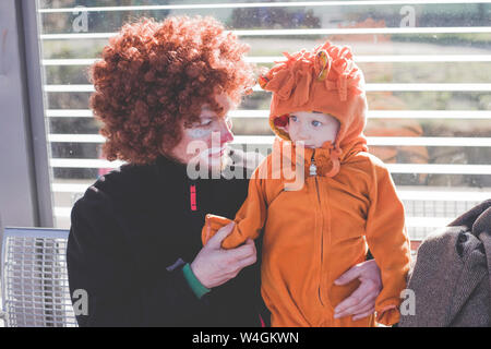 Mann verkleidet sich als Clown und kleinen Jungen als Lion Baby an Karneval verkleidet Stockfoto