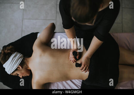 Junge Frau mit Beutel auf dem Rücken, während der Massage