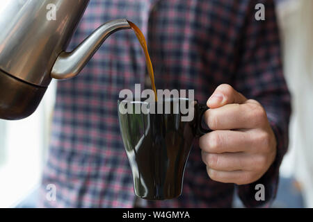 Man Kaffee in eine Schale giessen Stockfoto