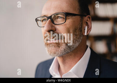 Portrait von Reifen Geschäftsmann Hören von Musik mit Bluetooth Ohrhörer Stockfoto