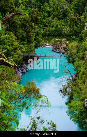 Schwingende Brücke über dem türkisfarbenen Wasser in Hokitika Gorge, Südinsel, Neuseeland Stockfoto