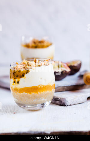 Ungebackene Käsekuchen in einem Glas mit Passionsfrucht und Mutter spröde Stockfoto