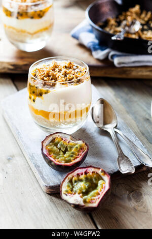 Ungebackene Käsekuchen in einem Glas mit Passionsfrucht und Mutter spröde Stockfoto