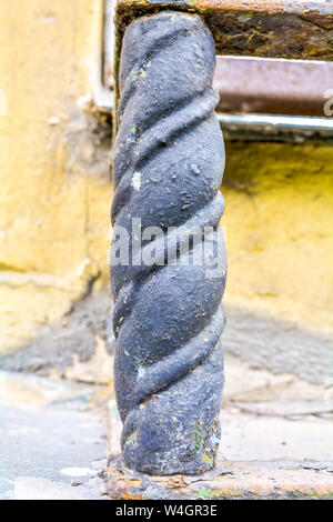 Dekorative Details des Gebäudes in Form einer rostigen Gusseisernen twisted Post vom Zaun des Fensters. Alte architektonische Element - Eine kleine Deco Stockfoto