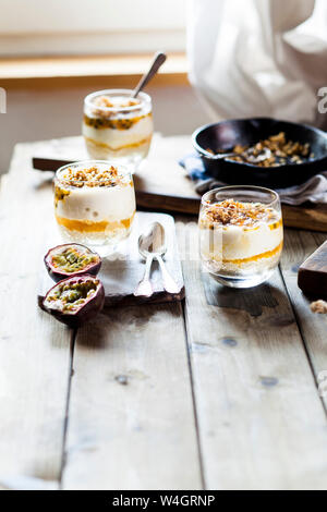 Ungebackene Käsekuchen in einem Glas mit Passionsfrucht und Mutter spröde Stockfoto