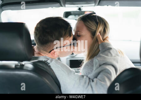 Junge Paar küssen in einem Auto Stockfoto
