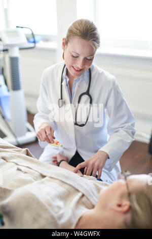 Weibliche Arzt eine Blutprobe von Patienten in der medizinischen Praxis Stockfoto