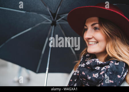 Portrait von glücklichen jungen Frau unter dem Dach Stockfoto