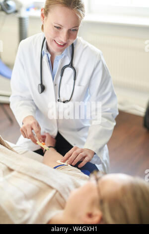 Weibliche Arzt eine Blutprobe von Patienten in der medizinischen Praxis Stockfoto