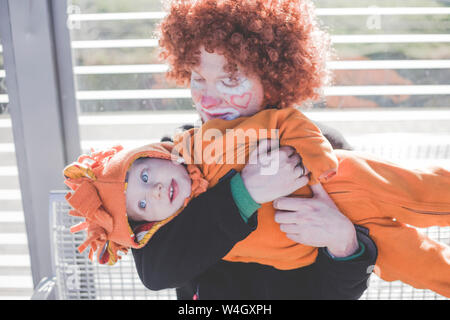 Mann verkleidet sich als Clown und kleinen Jungen als Lion Baby an Karneval verkleidet Stockfoto