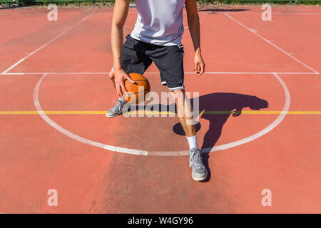 Junger Mann, Basketball spielen Stockfoto