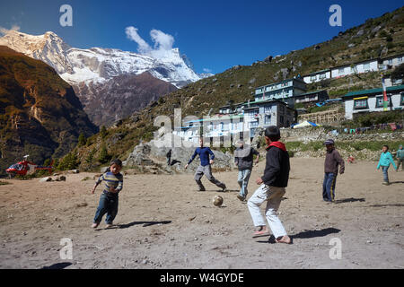 Namche Bazar, Nepal - Oktober 17, 2015: Unbekannte Kinder spielen Fußball auf staubigen Spielplatz, Namche Bazar Stockfoto