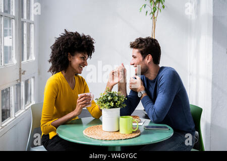 Gerne zärtlich Paar am Tisch zu Hause sitzen Stockfoto