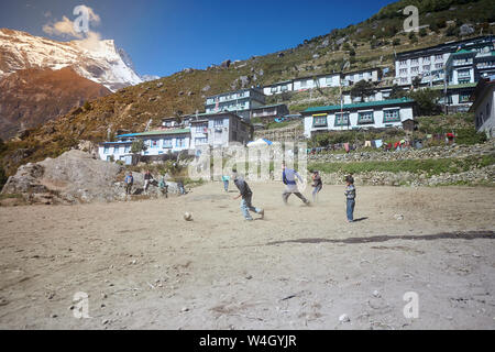 Namche Bazar, Nepal - Oktober 17, 2015: Unbekannte Kinder spielen Fußball auf staubigen Spielplatz, Namche Bazar Stockfoto