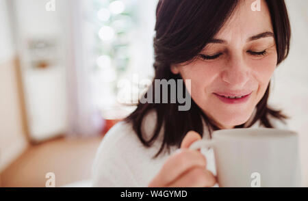 Reife Frau in einem Bad zu Hause genießen eine Tasse Kaffee Stockfoto