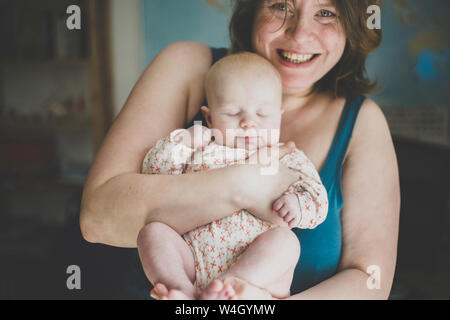 Glückliche Mutter ihr Baby Tochter Holding Stockfoto
