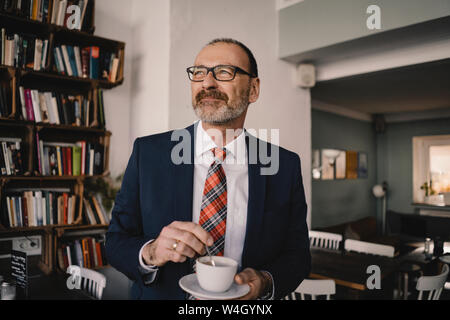 Reifen Geschäftsmann in einem Café bei einer Tasse Kaffee Stockfoto
