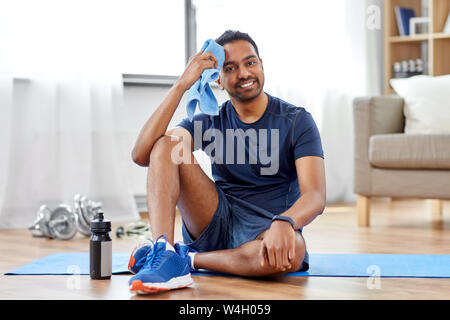 Müde indischen Mann mit Handtuch nach dem Training zu Hause Stockfoto