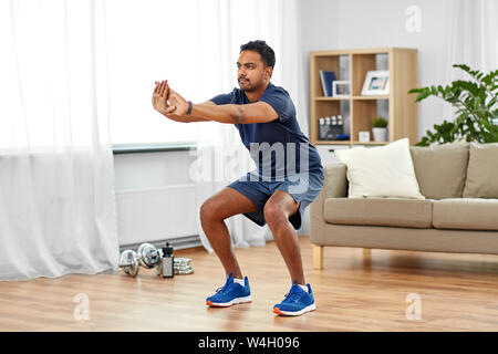 Inder trainieren und dabei hockt zu Hause Stockfoto