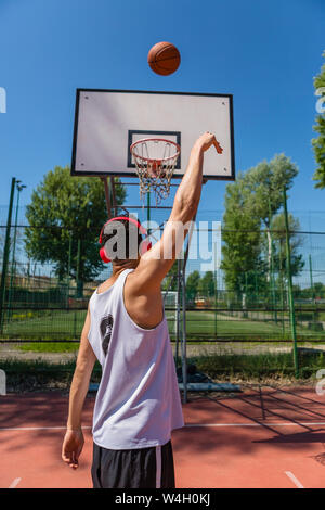 Junger Mann, Basketball spielen Stockfoto